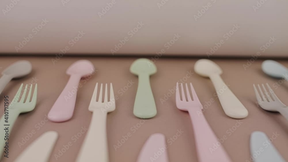 set of plastic reusable cutlery in different colors spoons forks knives on the kitchen table set of plastic reusable cutlery in different colors spoons forks knives on the kitchen table
