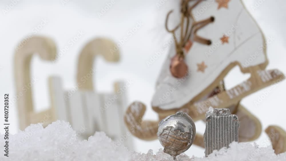 Wooden made mini sleighs and skating shoes in the snow. Free space for a text. Dynamic zoom Wooden made mini sleighs and skating shoes in the snow. Free space for a text. Dynamic zoom