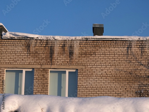 Icecicles on the roof. Bad thermal insulation concept photo