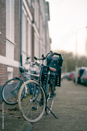 parked bicycle with a child seat in an urban street with parked cars