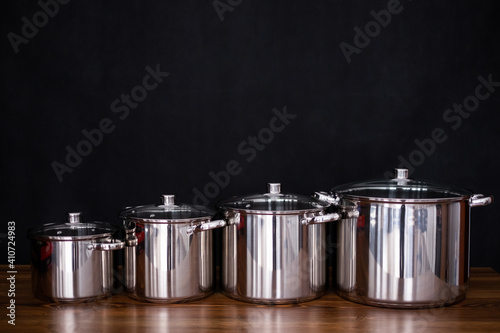 Set of grill pans on wooden table against black background, space for text