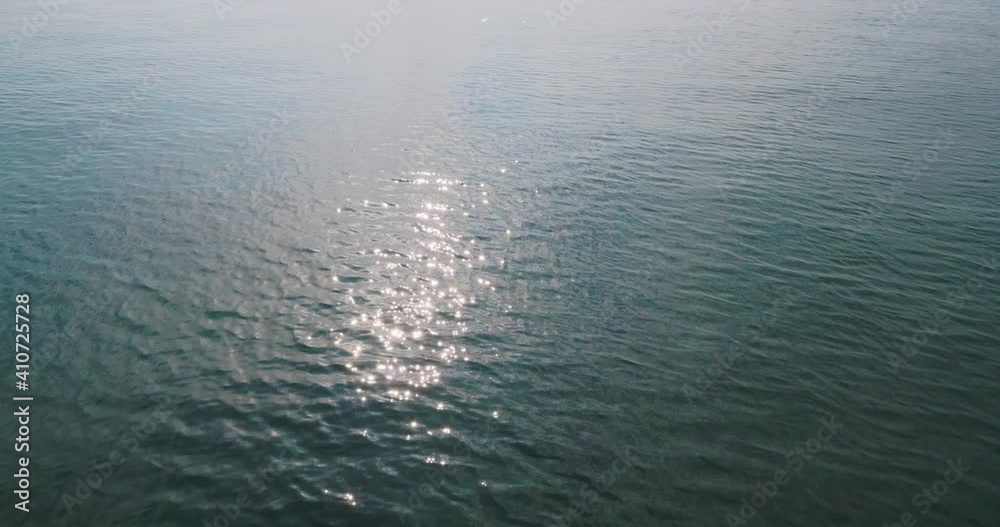 Sunbeams shine on sea surface. Sparkling sun reflection. Sunbeams shine on sea surface. Sparkling sun reflection.