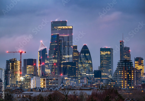 Cityscape view of the famous financial modern buildings in London illuminated at dusk