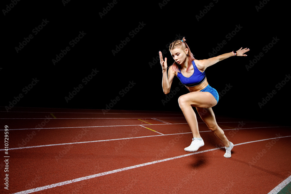 Female track runner bursting off starting block