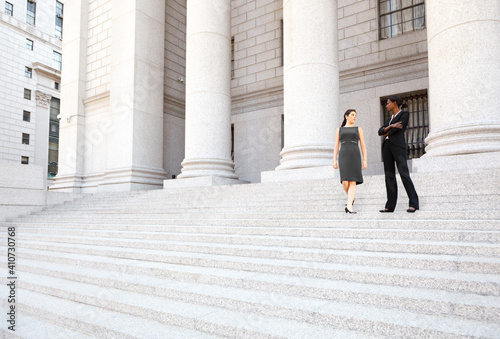 Two women in discussion on the exterior steps of a courthouse. Could be lawyers  business people etc.