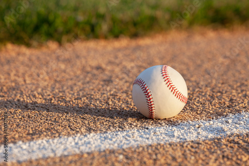 Low angle selective focus view of a baseball on a basepath with white stripe photo