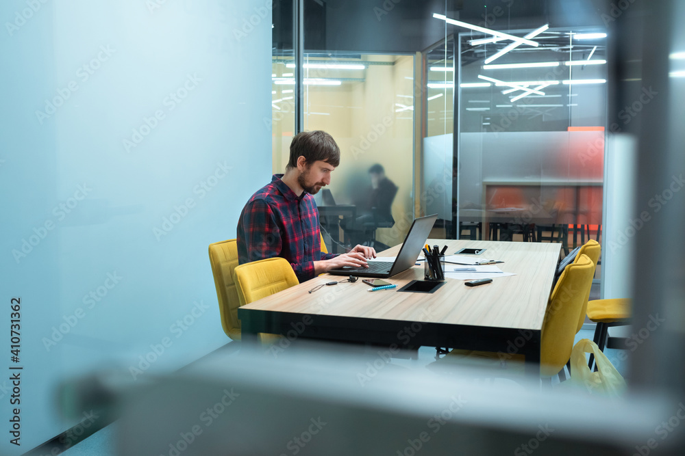 A young employee works on a computer during a working day in an office. Business development to success and growing growth concept. Co-working, Business and entrepreneurship concept A young employee works on a computer during a working day in an office. Business development to success and growing growth concept. Co-working, Business and entrepreneurship concept