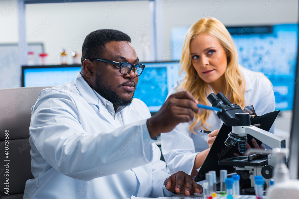 Professional team of scientists is working on a vaccine in a modern scientific research laboratory. Genetic engineer workplace. Future technology and science. Professional team of scientists is working on a vaccine in a modern scientific research laboratory. Genetic engineer workplace. Future technology and science.