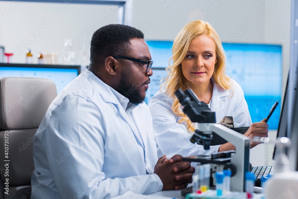 Professional team of scientists is working on a vaccine in a modern scientific research laboratory. Genetic engineer workplace. Future technology and science. Professional team of scientists is working on a vaccine in a modern scientific research laboratory. Genetic engineer workplace. Future technology and science.