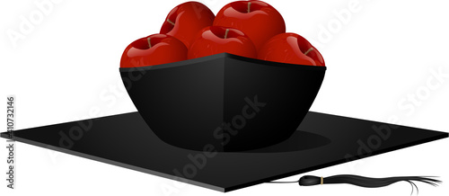 An upside down graduation cap used as a fruit bowl with apples inside.
