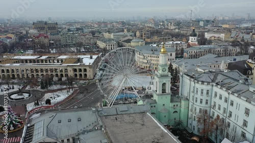 Europe, Kiev, Ukraine - February 2021: Aerial view of Kontraktova Square in the Podil area. Ferris wheel and Old residential buildings. photo