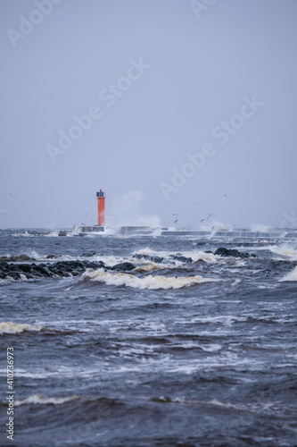 Waves crashing over a lighthouse, lighthouse in the sea in stormy day. Selective focus