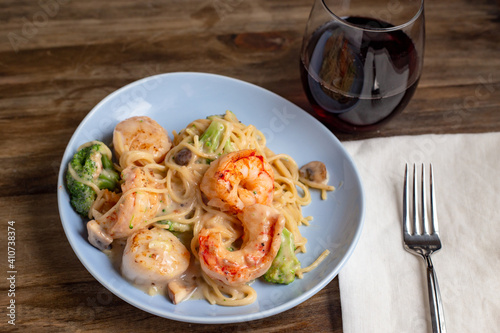 scallop and shrimp linguine meal with wine overhead