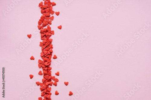 Abstract pink background with red sugar hearts. Valentine's day background.