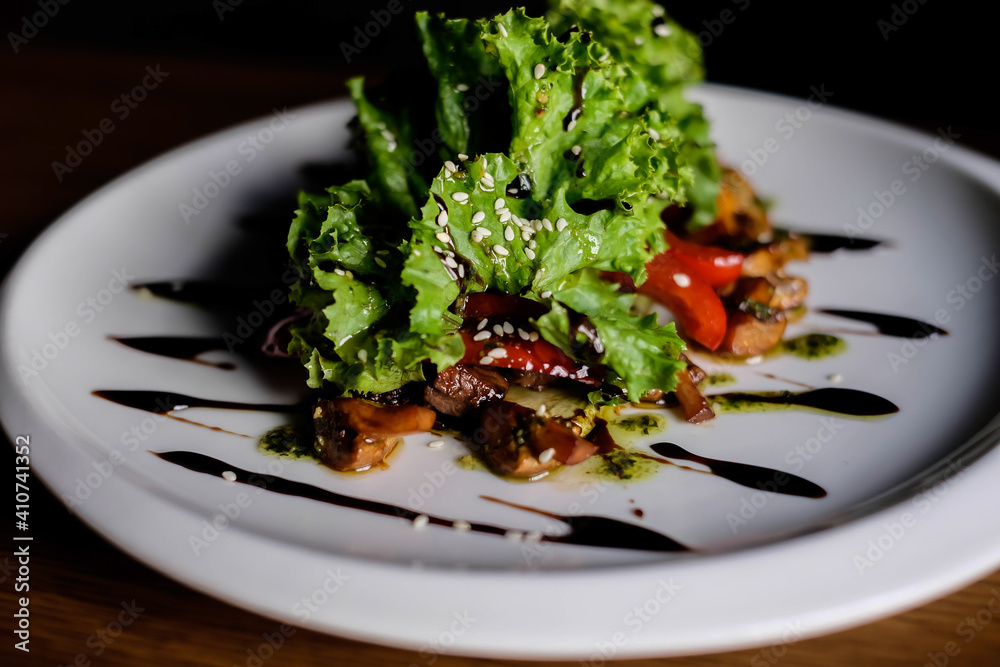 Delicious autumn mushroom salad with grilled mushrooms, tomato, fresh lettuce and rocket served in a bowl with toasted baguette