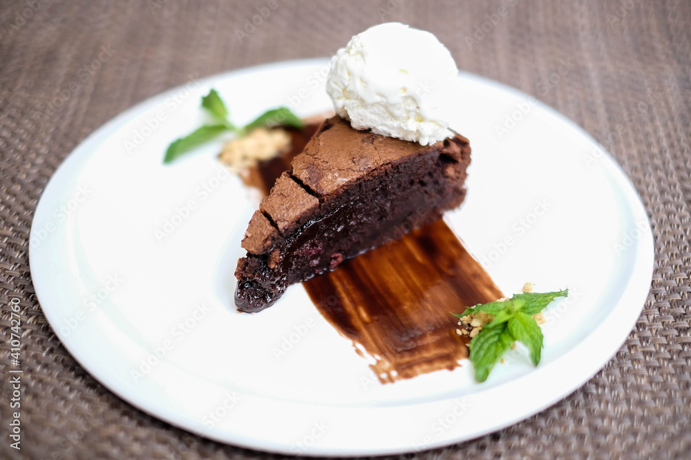 A slice of rich chocolate cake with a scoop of ice cream A slice of rich chocolate cake with a scoop of ice cream