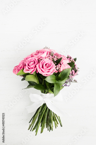 Beautiful bouquet of pink roses flowers with white bow for holiday gift