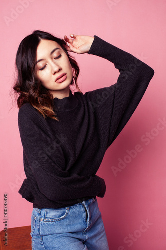 young pretty girl with curly hair posing cheerful on pink background, lifestyle people concept