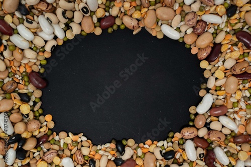 una cornice di legumi e cereali su sfondo nero photo