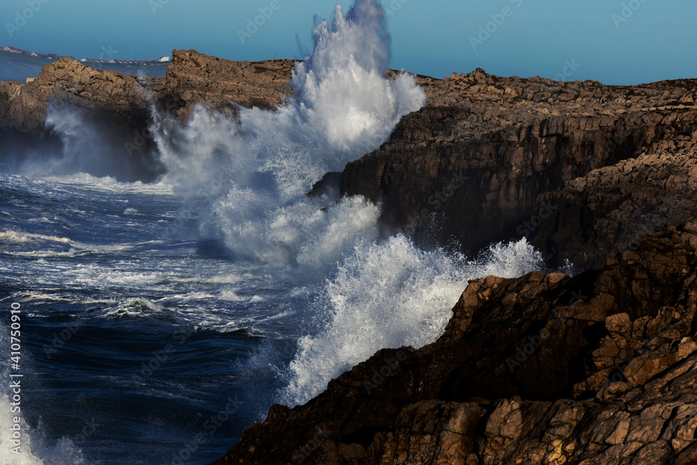 Huge waves hitting the cliff and exploding