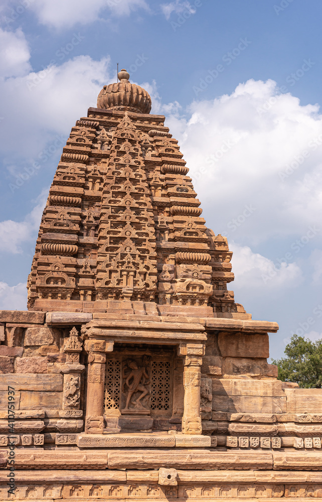 Bagalakote, Karnataka, India - November 7, 2013: Pattadakal temple complex. Closeup of Tall brown stone Galaganatha Temple vimanam tower with sculpture of Shiva killing Andhaka demon.