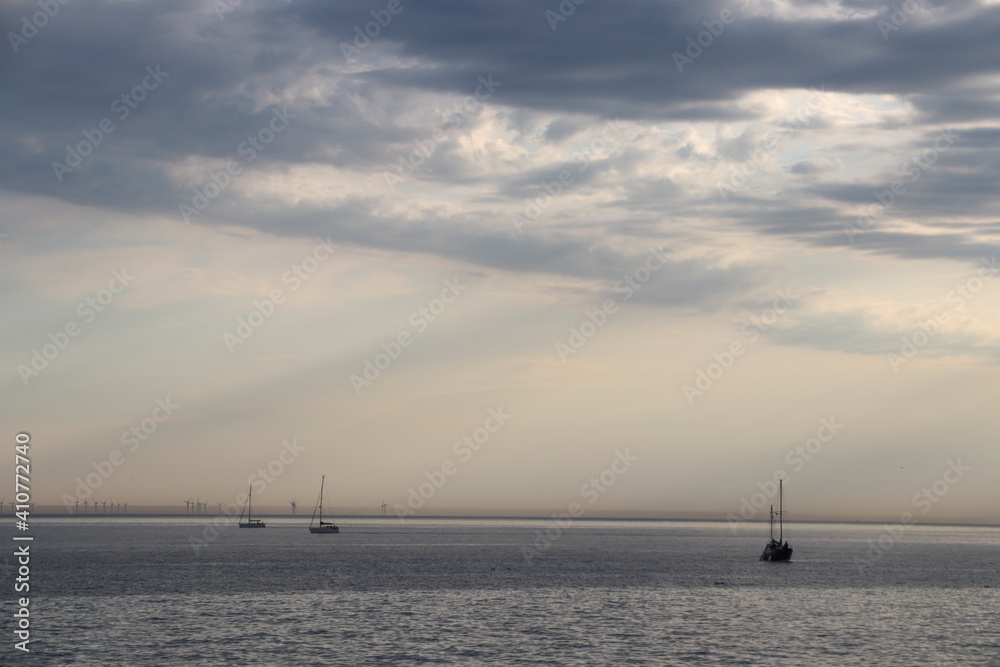yachts and boats float on the ocean under a beautiful sky