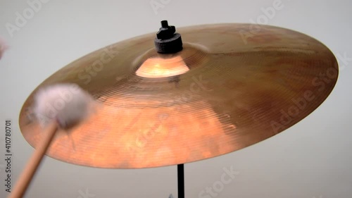A soft mallet roll is being performed on a cymbal to produce a rising then falling crescendo photo