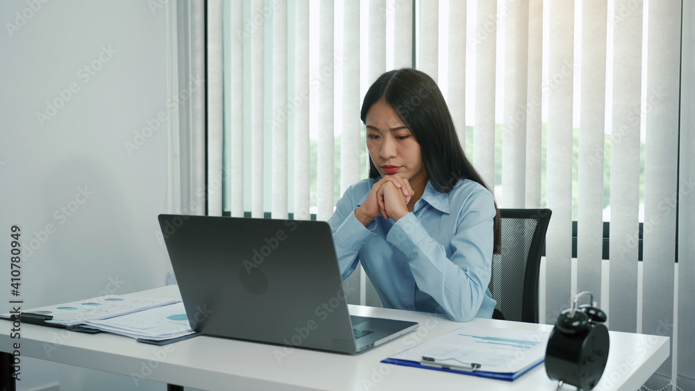 Young asian women are worried or stressed about working at the corporate office. Young asian women are worried or stressed about working at the corporate office.