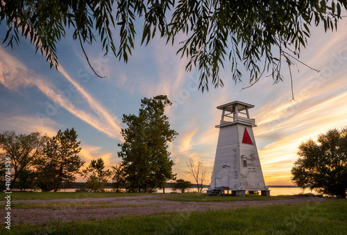Old Wooden Lighthouse at Sunset on a Tree-Lined River