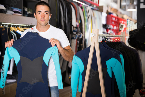 Young male chooses sportswear in a clothes store