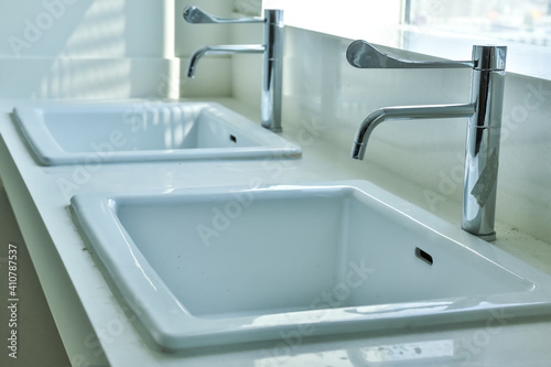 Ceramic sink and modern tap in stylish kitchen interior. Interior home styling classic and modern kitchen water tap.