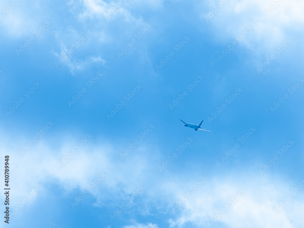 青空を上昇する飛行機