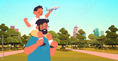 little son holding toy plane and sitting on father's shoulders parenting fatherhood concept dad walking with his kid in urban park portrait horizontal vector illustration