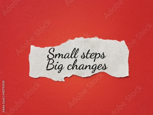 Inspirational and motivational quote. Phrase Small steps Big changes written on paper strip.