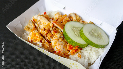 Ayam geprek or Spicy chicken crush with chilli and garlic flavour on white plate isolated on white background.