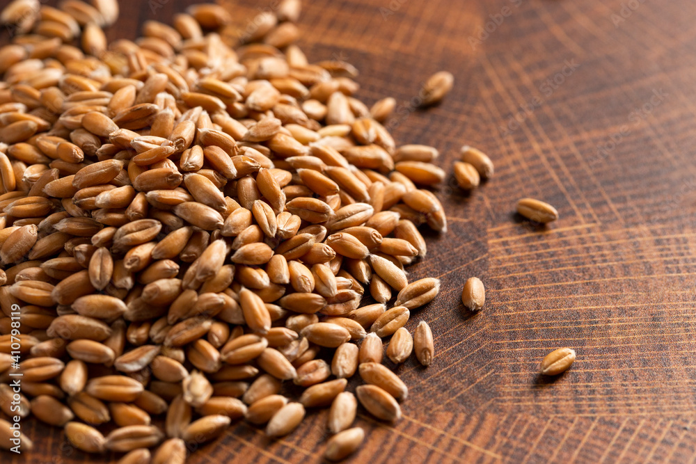Pile of Spelt Grain on a Wooden Butchers Block Pile of Spelt Grain on a Wooden Butchers Block