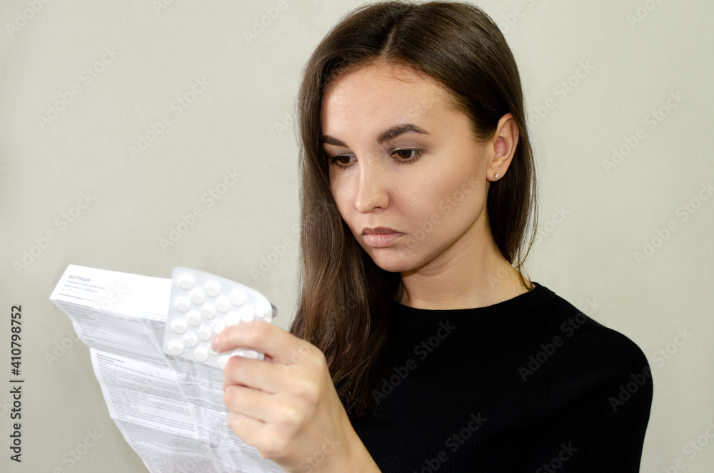 the girl reads the instructions for the pills the girl reads the instructions for the pills