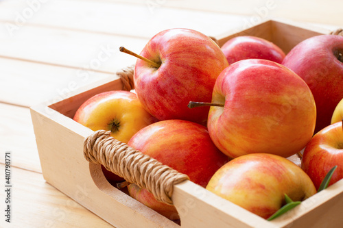Photos Red organic envy apple in crate isolated on wooden table background