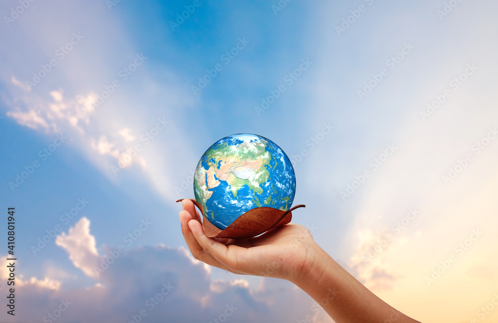 Hand holding the earth on dry leaf save the earth concept. sun set background.