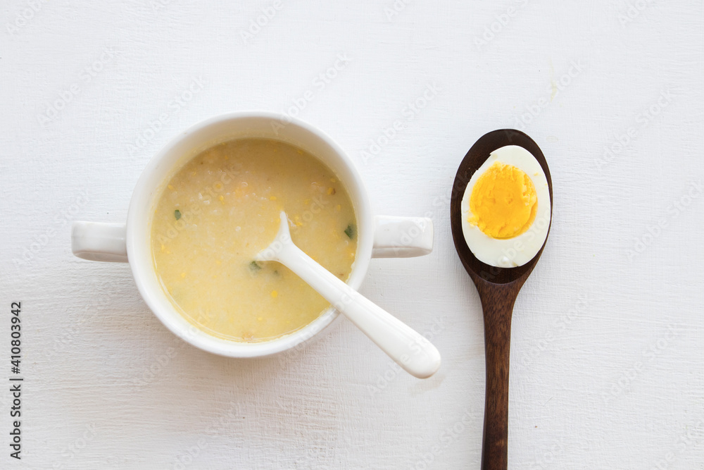 mix rice gruel and boiled egg yolk healthy foods health care for baby eats breakfast arrangement flat lay style on background white mix rice gruel and boiled egg yolk healthy foods health care for baby eats breakfast arrangement flat lay style on background white