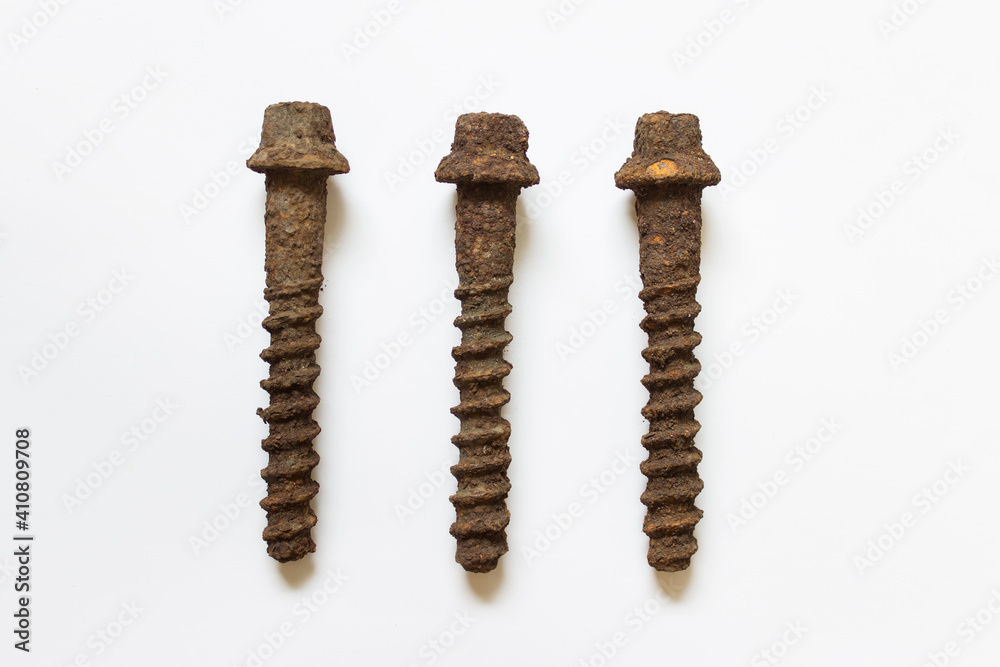 Large long rusted corroded screws used for railroad rails attachment on white background. Large long rusted corroded screws used for railroad rails attachment on white background.