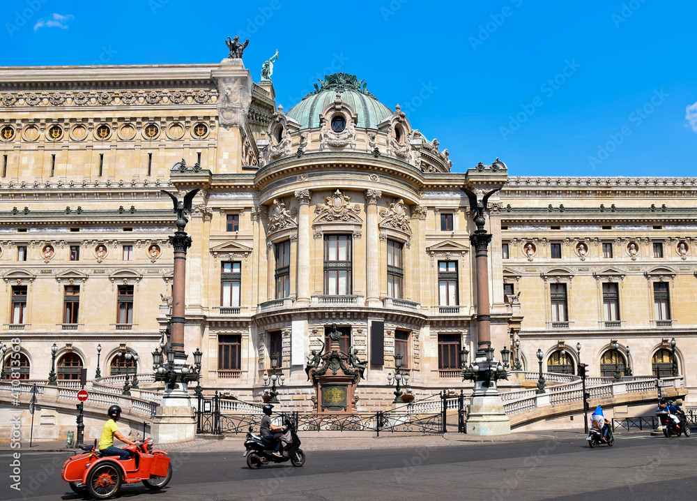 Motorcyclists ride past the beautiful Opera House in Paris, France