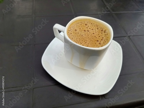 A tea or coffee cup on a table in a restaurant . Close up.