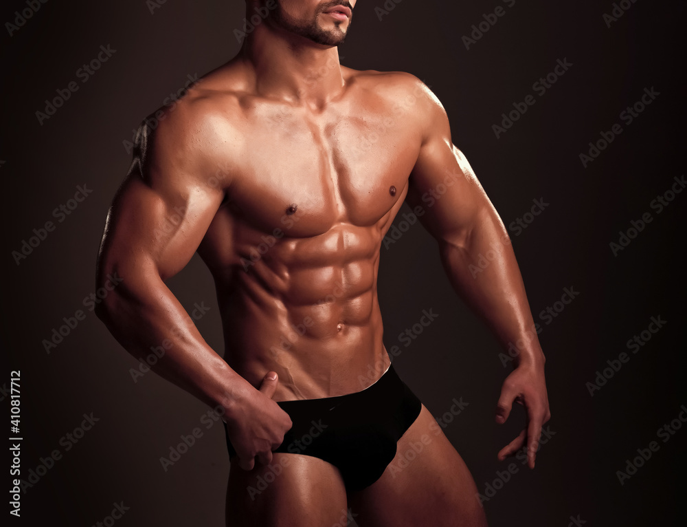 Athletic bodybuilder man on black background. Coach sportsman with bare chest in pants. Man with muscular body and torso. Dieting and fitness. Athletic bodybuilder man on black background. Coach sportsman with bare chest in pants. Man with muscular body and torso. Dieting and fitness.