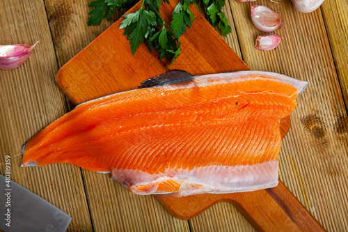 Fresh raw fillet of trout fish on wooden background