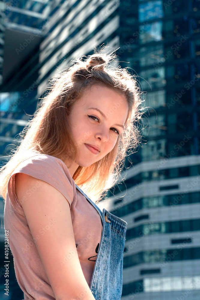 portrait of a beautiful red-haired teenager girl in a city urban landscape. backlight