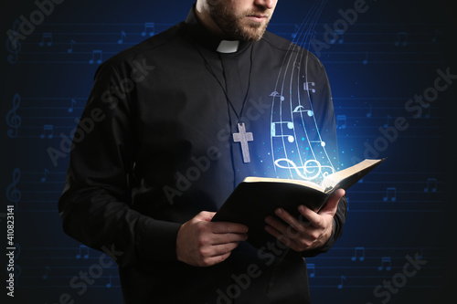 Male cantor with book on dark background