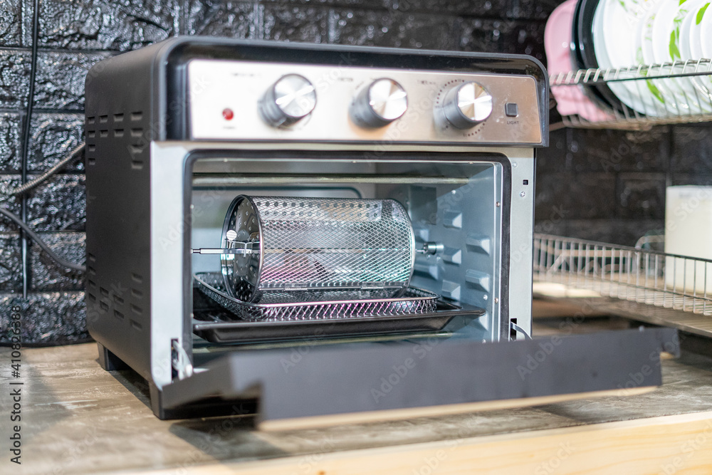 Electric oven cage or rotating basket inside air fryer oven. Modern technology kitchenware. Electric oven cage or rotating basket inside air fryer oven. Modern technology kitchenware.