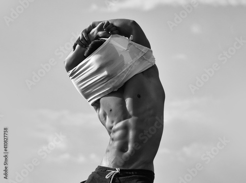 Sensual sexy gay. Man in shirt undressing with bare muscular torso and maked body.