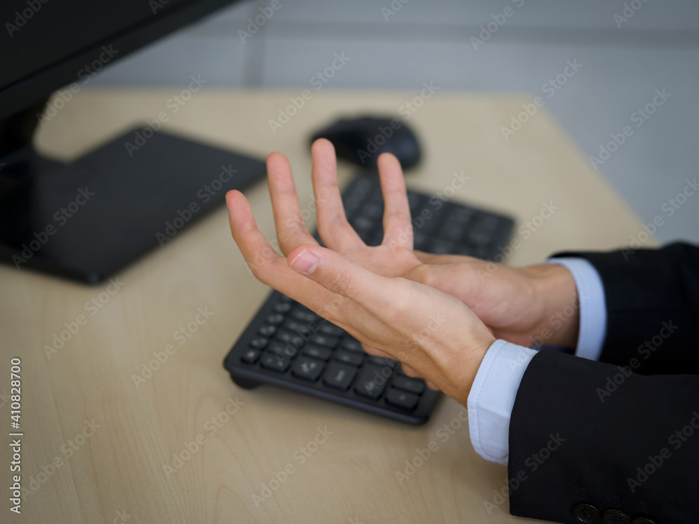 A young man injured his hand from using a computer for a long time. Close up A young man injured his hand from using a computer for a long time. Close up